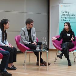 The keynote speakers discussing their research with Professor Sir John Aston