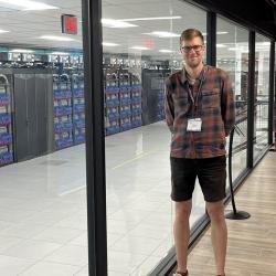 Maximilian Kraus next to the AURORA supercomputer