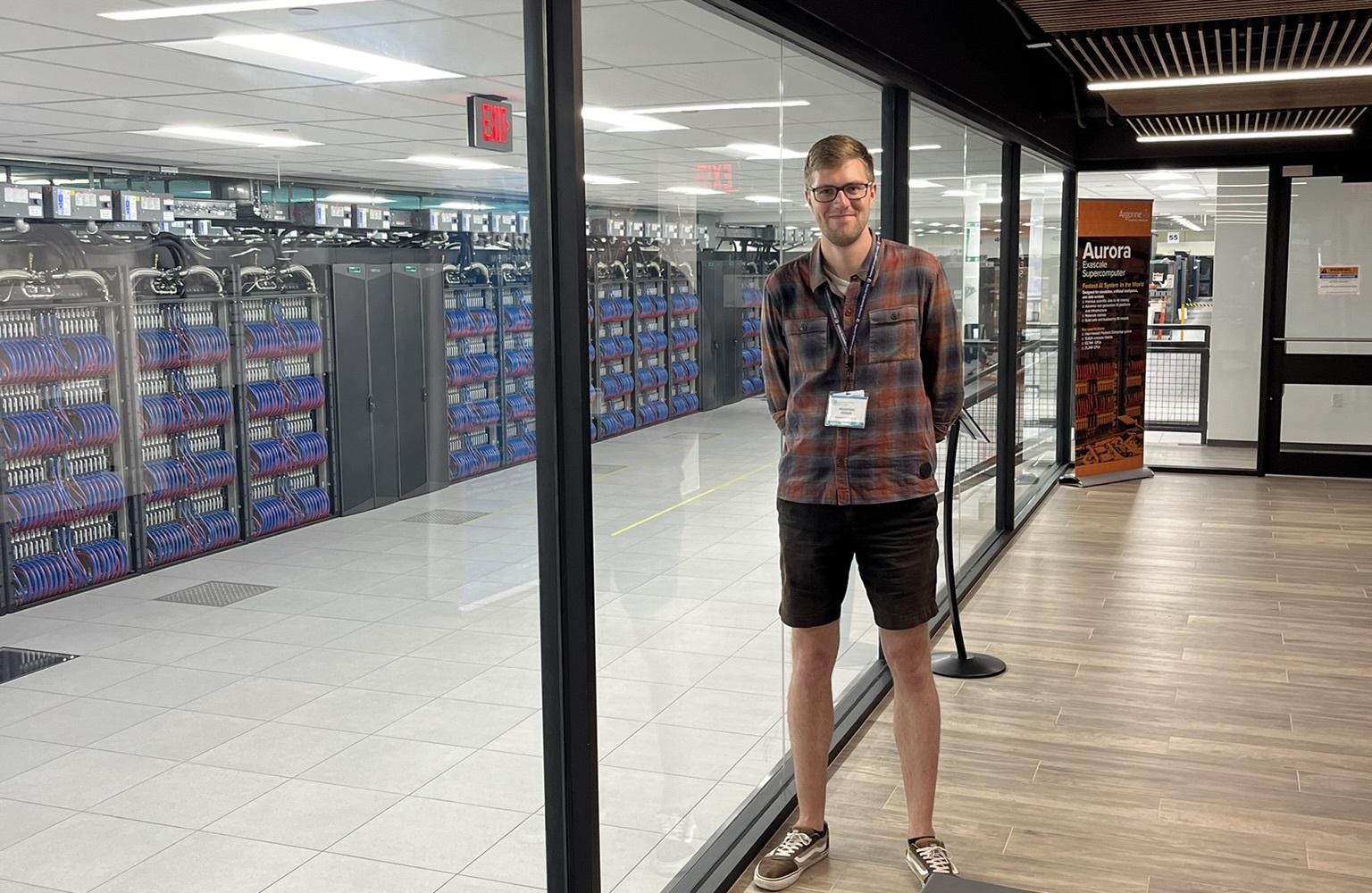 Maximilian Kraus next to the AURORA supercomputer